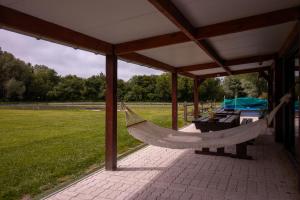a hammock on a pavilion with a grass field at Aux étangs in Brutelles