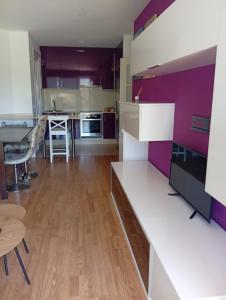 a kitchen with purple and white cabinets and a table at Apartamento en Playa de Altar in Barreiros