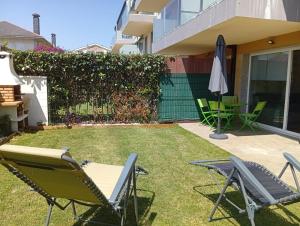 a backyard with lawn chairs and an umbrella at Apartamento en Playa de Altar in Barreiros +7 photos
