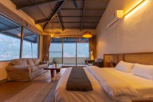 a bedroom with a large bed and a couch at Over The World in Rāmgarh