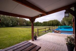 a pavilion with a picnic table and a playground at Aux étangs in Brutelles