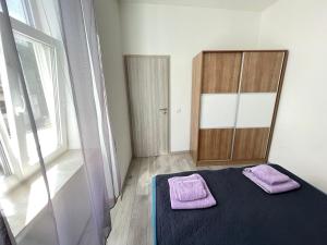 a bedroom with a bed with two purple towels on it at Villa History in Crikvenica +1 photo