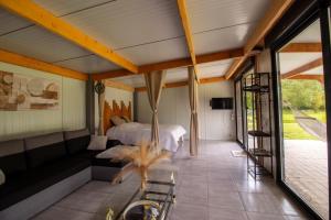 a bedroom with a bed and a couch at Aux étangs in Brutelles