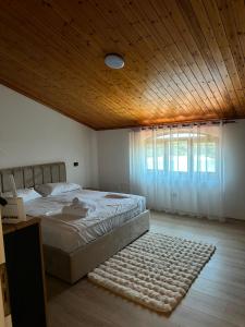 a bedroom with a bed and a wooden ceiling at Drini river view in Shkodër