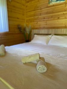 a pair of towels on a bed in a bedroom at Hotel Restorant Natyra Diber Camping in Podgorcë