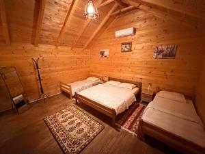 a room with two beds in a wooden cabin at Valbone Two E in Valbonë