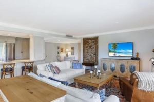 a living room with a white couch and a table at Two Bedroom Bayfront Condo with Water Views in Naples