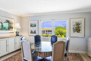 a dining room with a glass table and chairs at Two Bedroom Bayfront Condo with Water Views in Naples