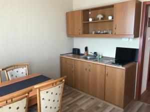 a kitchen with a sink and a table with chairs at Thermal Apartman 01 in Kiskőrös