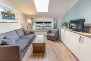 a living room with a couch and a television at Hölbinger Alm - Apartments in Anger