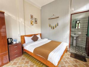 a bedroom with a bed and a bathroom with a sink at Nấm Homestay in Sapa