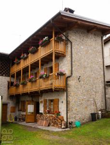 ein Gebäude mit Holzbalkonen und Blumen darauf in der Unterkunft Dependance GRIMANI in Ampezzo