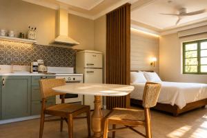 a kitchen and a bedroom with a bed and a table at Athena Collection in Kefalos