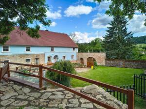 a large white house with a fence and a yard at Statek Bílý Dvůr in Machov