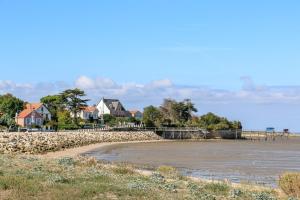a view of a beach with houses in the background at L'Océane - Maison au calme avec terrasse, centre de Bourg in Le Port-des-Barques +3 photos