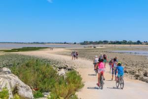a group of people riding bikes on a beach at L'Océane - Maison au calme avec terrasse, centre de Bourg in Le Port-des-Barques