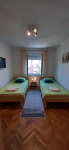 two beds sitting in a room with a window at Apartman Dejanović 1 in Veliko Gradište