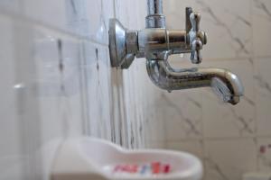 a faucet with water coming out of it next to a sink at Kolstar Hotel SMC Ltd in Ogwam +13 photos