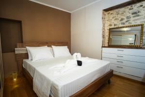 a bedroom with a bed with a dresser and a mirror at Joanna's House in Koumaradaíoi