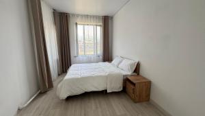a small bedroom with a bed and a window at Guest House Alim in Karakol