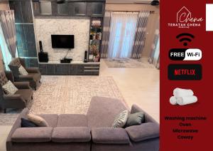 a living room with a couch and a tv at Teratak Chena - Lux Bungalow in Kuala Terengganu