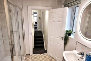 a bathroom with a shower and a sink and a mirror at Newly Refurbished Townhouse in Derry Londonderry