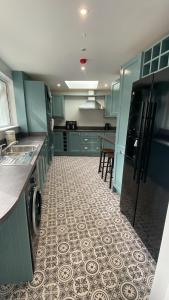 a kitchen with green cabinets and a tile floor at Newly Refurbished Townhouse in Derry Londonderry