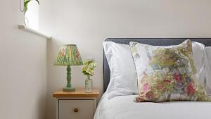 a bed with a pillow and a lamp on a night stand at Applewood in Harome