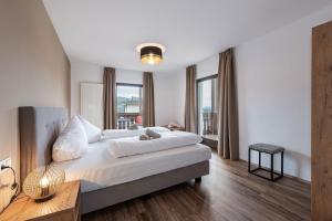 a bedroom with a large bed with white sheets at Aparthotel Feldhof Nature in Bolzano