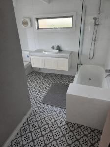 a bathroom with a sink and a tub and a toilet at Tranquillity by the sea in Killarney +6 photos