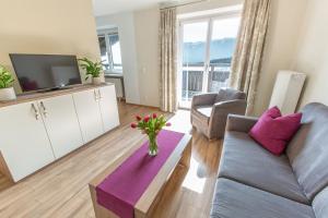 a living room with a couch and a tv at Hölbinger Alm - Apartments in Anger