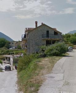 ein altes Backsteinhaus am Straßenrand in der Unterkunft Radoš in Igalo