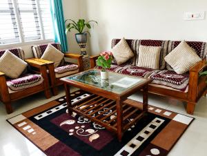 a living room with a couch and a coffee table at Neartown Homestay in Kushālnagar