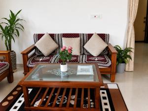 a living room with a couch and a coffee table at Neartown Homestay in Kushālnagar +19 photos
