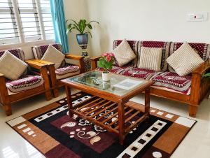 a living room with a couch and a coffee table at Neartown Homestay in Kushālnagar