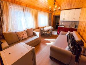 a living room with a couch and a table and a kitchen at ADiLOGLU PANSiYON in Uzungöl