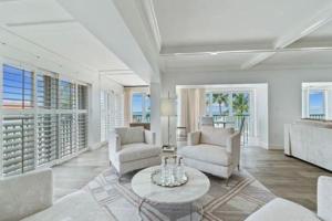 a living room with two chairs and a table at Three Bedroom Gulffront Condo with Sunset Views in Naples