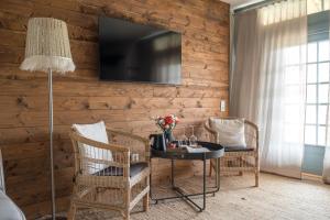 a room with a table and chairs and a television on a wall at Gumbalde Resort in Stånga