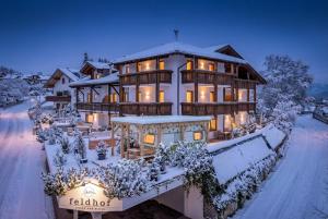 a large house with snow on the ground at Aparthotel Feldhof Nature in Bolzano