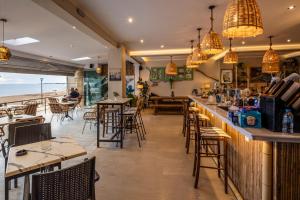 a restaurant with tables and chairs and a bar at Marea Blue Seaview Apartments of Santa Barbara in Marathias