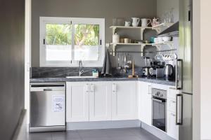 a kitchen with white cabinets and a window at Views Spacious Villa in El Rincón +9 photos