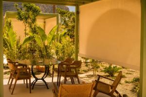 a patio with a table and chairs and a window at Athena Collection in Kefalos