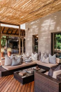 a living room with a couch on a wooden deck at Moditlo River Lodge in Hoedspruit