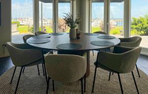 a dining room table with chairs and a large window at Awesome Home In Haderslev With Sauna in Haderslev