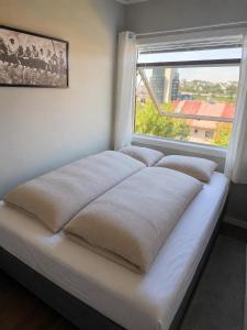 a bed in a room with a window at Tøttatoppen leilighet in Narvik