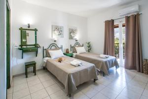 a room with two beds and a mirror at Pavlos Maria studios in Skiathos +47 photos