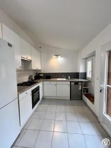 a kitchen with white cabinets and a white tile floor at Rafael in Quintillan +9 photos