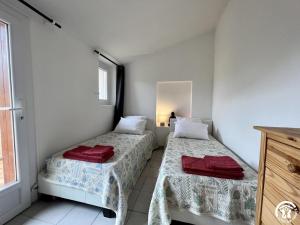 two beds in a room with white walls and a window at Rafael in Quintillan