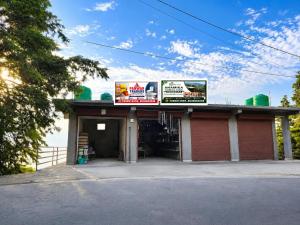 a building with signs on the top of it at Anamika Forest View 1RK Near Kempty Falls Mussoorie in Mussoorie