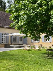 two lounge chairs in the grass in front of a house at Moulin Dorceau - 15 couchages - voir notre site in Rémalard